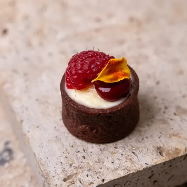 Mousse de chocolate blanco con yogur, frambuesas en una tartaleta de cacao